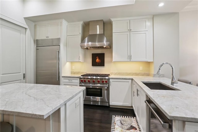 111 Audubon St Unit 202, New Orleans, LA 70118 - kitchen with premium appliances, wall chimney range hood, recessed lighting, dark wood-style flooring, and a peninsula