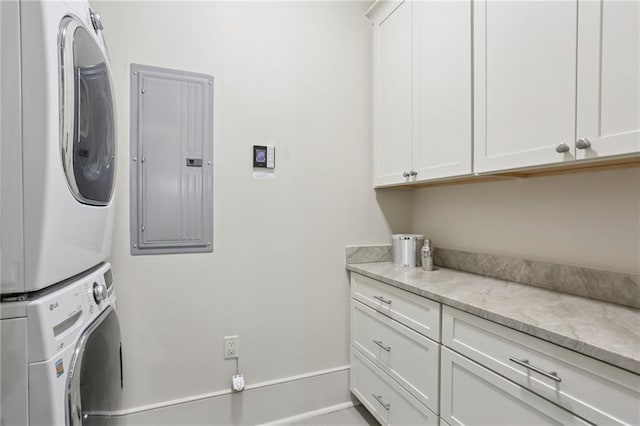 111 Audubon St Unit 202, New Orleans, LA 70118 - laundry room featuring stacked washer / dryer, electric panel, and cabinet space