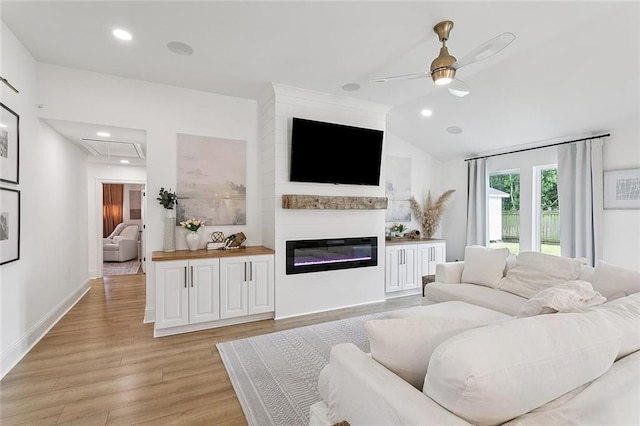 4548 Alphonse Dr, Metairie, LA 70006 - living room featuring attic access, a ceiling fan, light wood-style floors, vaulted ceiling, and a glass covered fireplace