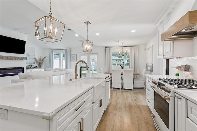 4548 Alphonse Dr, Metairie, LA 70006 - kitchen with white gas range, premium range hood, a chandelier, open floor plan, and recessed lighting
