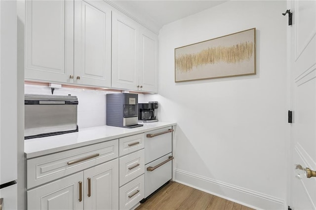4548 Alphonse Dr, Metairie, LA 70006 - kitchen featuring light wood-style floors, white cabinetry, light countertops, and decorative backsplash