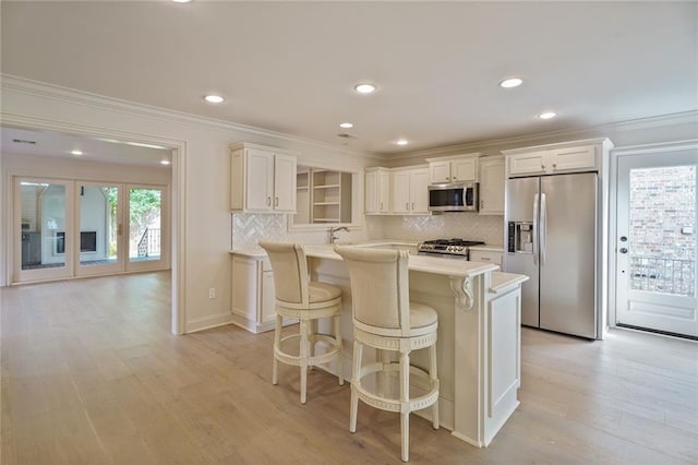 2232 N Starrett Rd, Metairie, LA 70003 - kitchen featuring stainless steel appliances, light countertops, a kitchen bar, crown molding, and white cabinetry