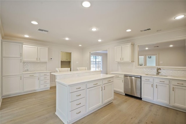 2232 N Starrett Rd, Metairie, LA 70003 - kitchen featuring stainless steel dishwasher, ornamental molding, decorative backsplash, white cabinets, and light countertops