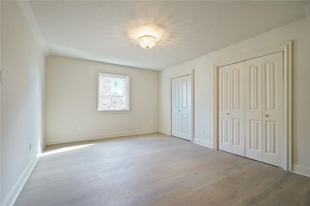 2232 N Starrett Rd, Metairie, LA 70003 - unfurnished bedroom with multiple closets and wood finished floors