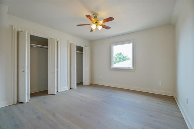 2232 N Starrett Rd, Metairie, LA 70003 - unfurnished bedroom with multiple closets, light wood finished floors, and a ceiling fan