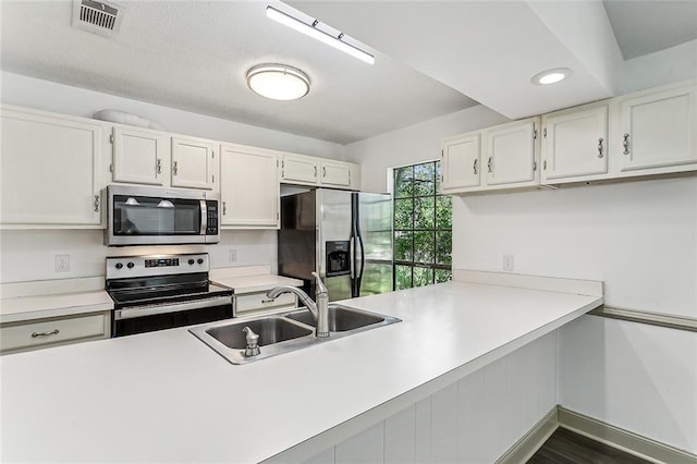 32 S Court Villa Dr Unit 32, Mandeville, LA 70471 - kitchen with appliances with stainless steel finishes, light countertops, white cabinets, a peninsula, and recessed lighting