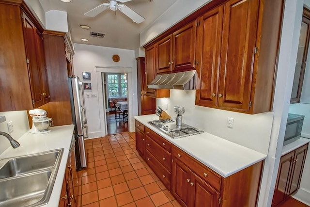 2410 Adams St, New Orleans, LA 70125 - kitchen with stainless steel appliances, under cabinet range hood, tile patterned floors, light countertops, and ceiling fan