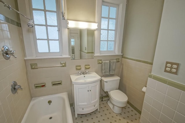 2410 Adams St, New Orleans, LA 70125 - full bathroom with healthy amount of natural light, tile walls, vanity, wainscoting, and shower / bath combination