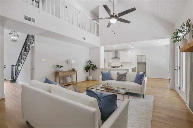 773 Rue Calais, Mandeville, LA 70471 - living room featuring high vaulted ceiling, a ceiling fan, light wood-type flooring, and stairs