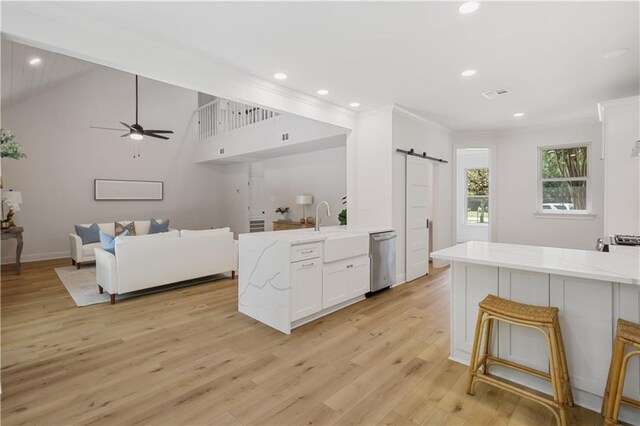 773 Rue Calais, Mandeville, LA 70471 - kitchen featuring dishwasher, a barn door, a peninsula, white cabinets, and light stone countertops