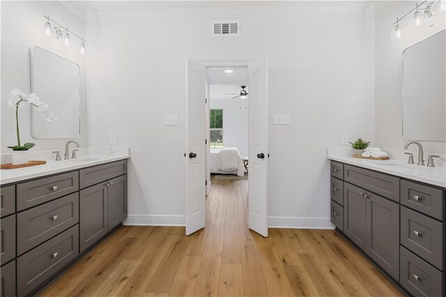 773 Rue Calais, Mandeville, LA 70471 - ensuite bathroom featuring ornamental molding, two vanities, wood finished floors, and a ceiling fan