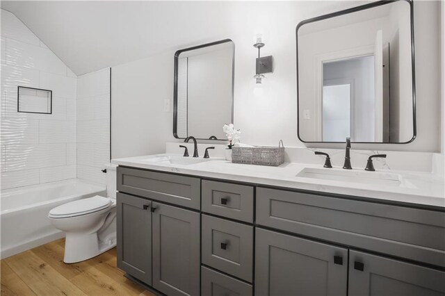 773 Rue Calais, Mandeville, LA 70471 - full bathroom with double vanity, wood finished floors, lofted ceiling, and bathing tub / shower combination