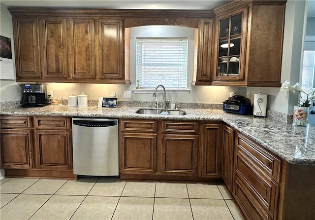 4908 David Dr, Kenner, LA 70065 - kitchen featuring stainless steel dishwasher, light tile patterned floors, glass insert cabinets, and light stone countertops