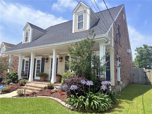 4908 David Dr, Kenner, LA 70065 - cape cod house with covered porch, roof with shingles, a gate, and brick siding