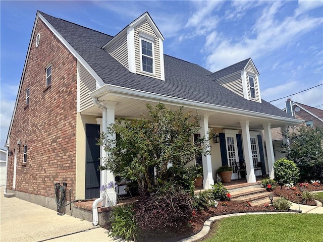 4908 David Dr, Kenner, LA 70065 - view of front of property featuring a porch, brick siding, a shingled roof, and a garage