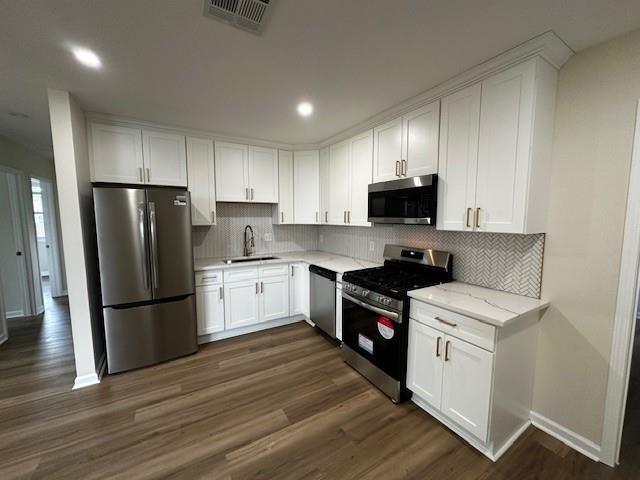 1018 Marian Ave, Metairie, LA 70001 - kitchen featuring appliances with stainless steel finishes, white cabinetry, dark wood-style flooring, and recessed lighting