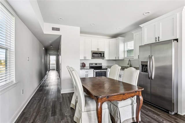 301113 Wall Blvd, New Orleans, LA 70114 - kitchen featuring stainless steel appliances, dark wood finished floors, white cabinetry, and recessed lighting