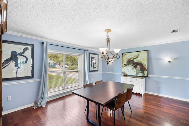 708 W Colorado Ave, Hammond, LA 70401 - dining area featuring a chandelier, a textured ceiling, ornamental molding, and dark wood-type flooring