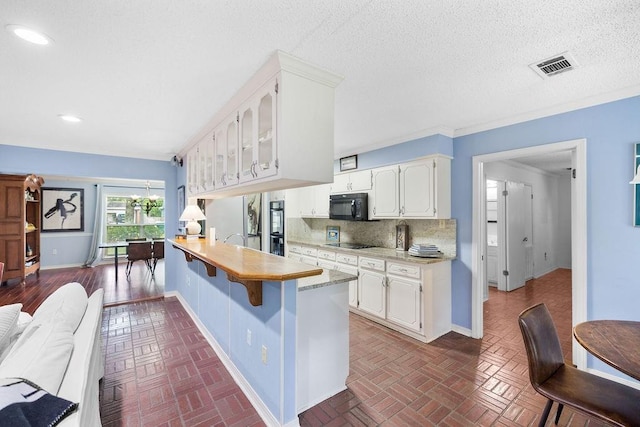 708 W Colorado Ave, Hammond, LA 70401 - kitchen with black appliances, a peninsula, light countertops, a breakfast bar area, and recessed lighting