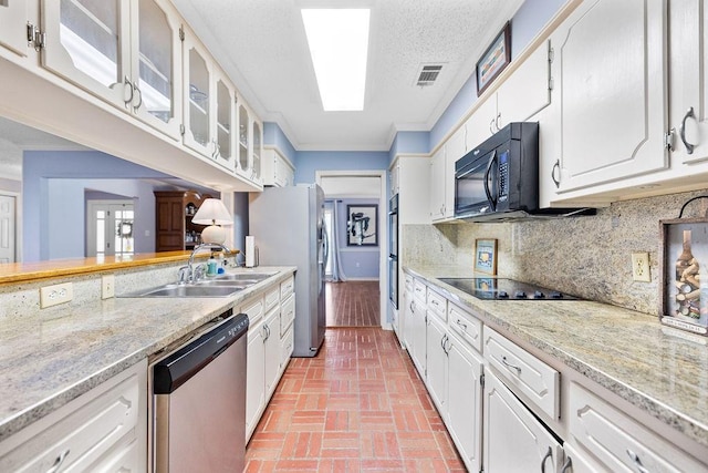 708 W Colorado Ave, Hammond, LA 70401 - kitchen featuring black appliances, brick patterned floors, white cabinetry, glass insert cabinets, and ornamental molding