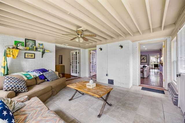 708 W Colorado Ave, Hammond, LA 70401 - living room featuring brick wall, tile patterned floors, beam ceiling, a ceiling fan, and french doors