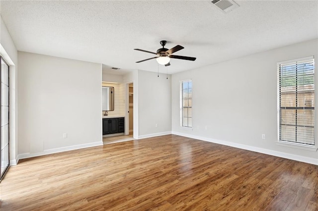 811 Franklin Ct, Slidell, LA 70458 - unfurnished living room featuring plenty of natural light, light wood-type flooring, ceiling fan, and a textured ceiling