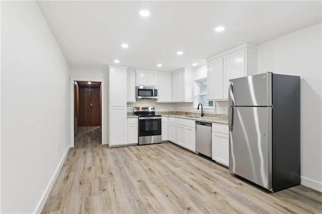 310 Blackburn Rd, Hammond, LA 70401 - kitchen with appliances with stainless steel finishes, white cabinets, light wood-style floors, recessed lighting, and light stone countertops