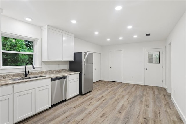 310 Blackburn Rd, Hammond, LA 70401 - kitchen with stainless steel appliances, light wood-type flooring, white cabinetry, recessed lighting, and light stone countertops