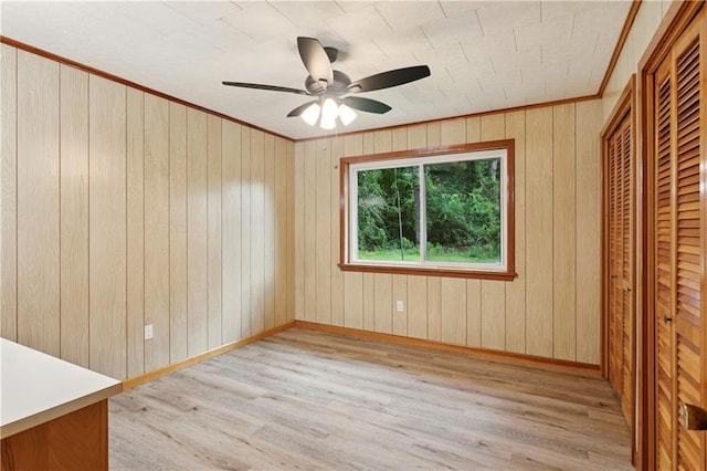 310 Blackburn Rd, Hammond, LA 70401 - unfurnished bedroom with light wood-style flooring, ornamental molding, a closet, wood walls, and a ceiling fan