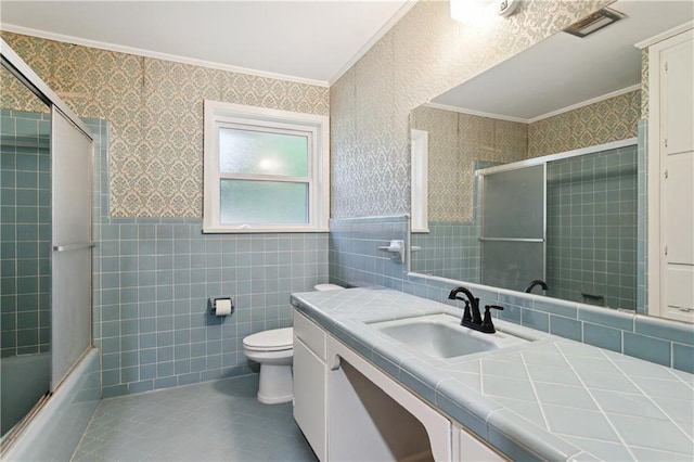 310 Blackburn Rd, Hammond, LA 70401 - full bath with ornamental molding, vanity, tile walls, tile patterned floors, and bath / shower combo with glass door