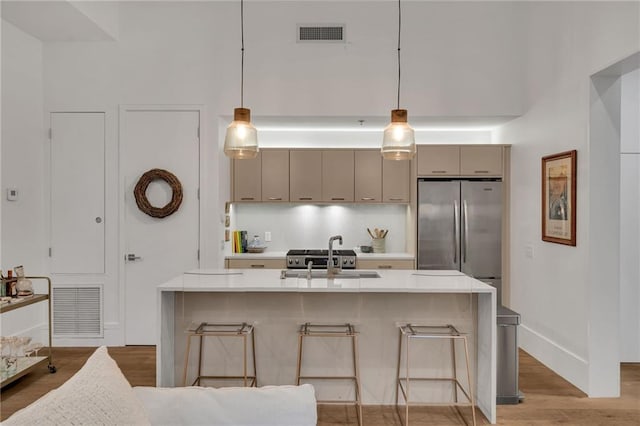 5940 Magazine St Unit 102, New Orleans, LA 70115 - kitchen with freestanding refrigerator, light countertops, a breakfast bar area, and light wood-style flooring