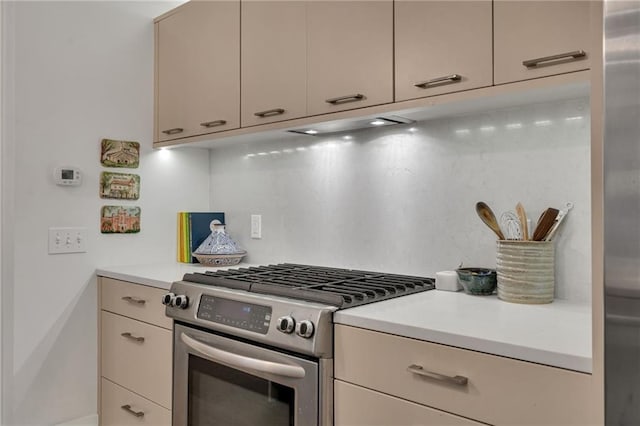 5940 Magazine St Unit 102, New Orleans, LA 70115 - kitchen featuring gas stove, light countertops, decorative backsplash, and cream cabinets