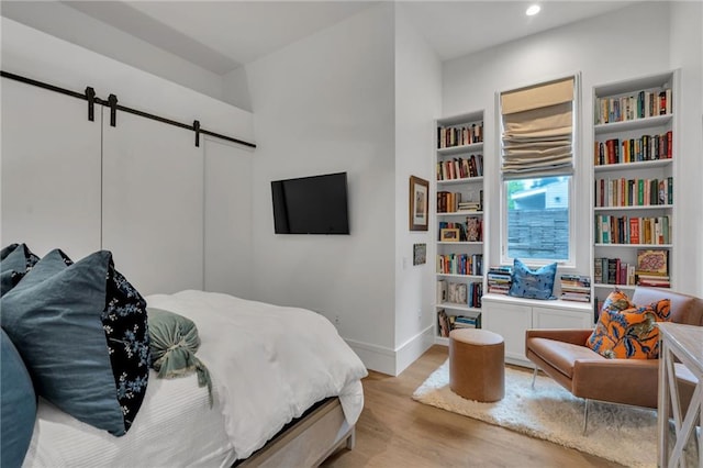 5940 Magazine St Unit 102, New Orleans, LA 70115 - bedroom featuring wood finished floors, a barn door, and recessed lighting