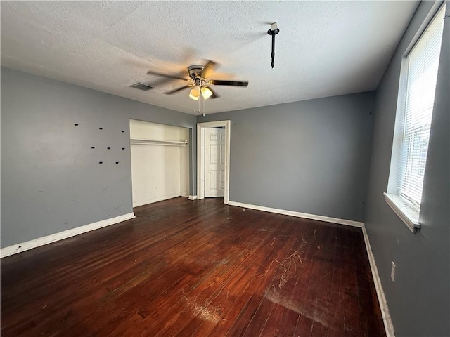 482022 Dauphine St, New Orleans, LA 70117 - unfurnished bedroom with hardwood / wood-style floors, a closet, ceiling fan, and a textured ceiling