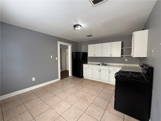 482022 Dauphine St, New Orleans, LA 70117 - kitchen with black appliances, open shelves, light countertops, white cabinets, and light tile patterned floors