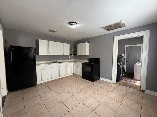 482022 Dauphine St, New Orleans, LA 70117 - kitchen with black appliances, independent washer and dryer, open shelves, light tile patterned floors, and white cabinetry