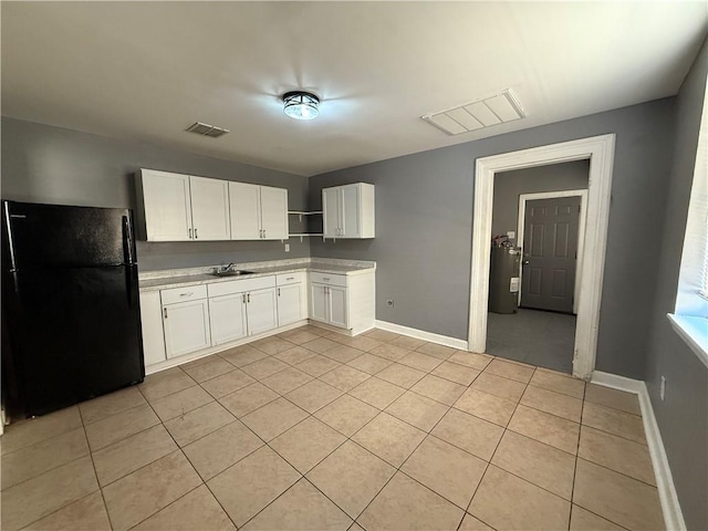 482022 Dauphine St, New Orleans, LA 70117 - kitchen with freestanding refrigerator, light tile patterned floors, water heater, and light countertops