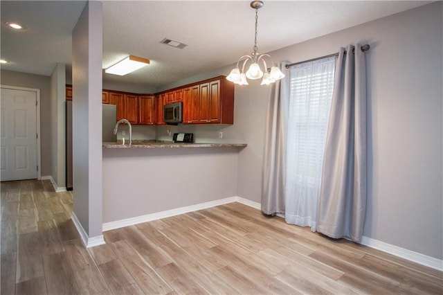 1700 Marseille Dr Unit 16, La Place, LA 70068 - kitchen with appliances with stainless steel finishes, light countertops, light wood-type flooring, brown cabinets, and recessed lighting