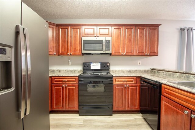 1700 Marseille Dr Unit 16, La Place, LA 70068 - kitchen with black appliances, light countertops, a textured ceiling, and light wood-style flooring