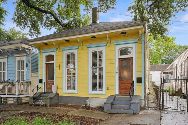 232830 Bienville St, New Orleans, LA 70119 - shotgun-style home featuring entry steps, a gate, and a chimney