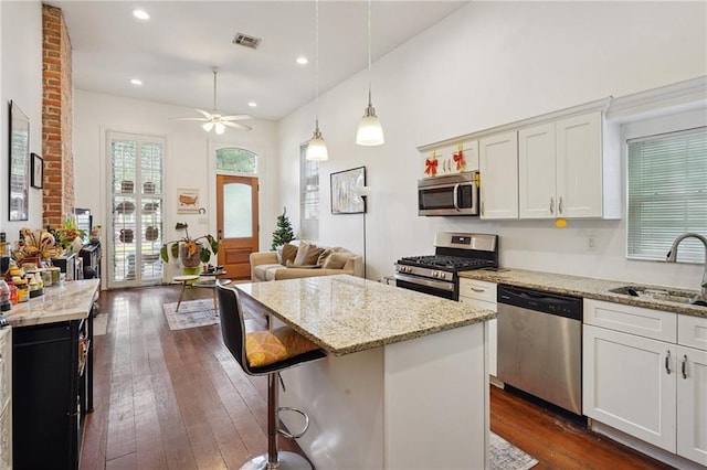 232830 Bienville St, New Orleans, LA 70119 - kitchen featuring appliances with stainless steel finishes, a ceiling fan, dark wood finished floors, light stone counters, and recessed lighting