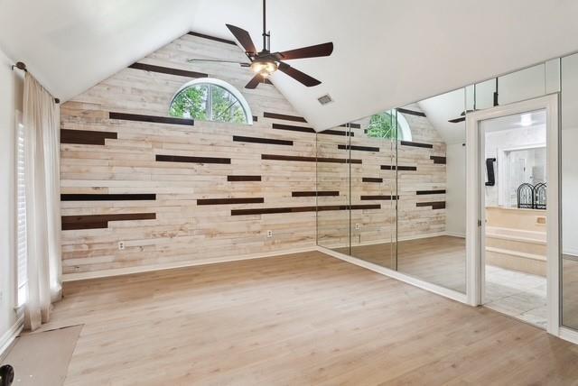 107 Quail St, Slidell, LA 70460 - spare room with wood walls, wood finished floors, a ceiling fan, and high vaulted ceiling