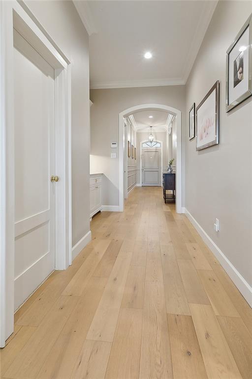 1193 Delta Ln, Covington, LA 70433 - hallway with arched walkways, ornamental molding, light wood-type flooring, and recessed lighting