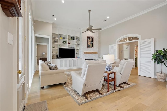 1193 Delta Ln, Covington, LA 70433 - living area with crown molding, ceiling fan, built in shelves, a large fireplace, and light wood finished floors