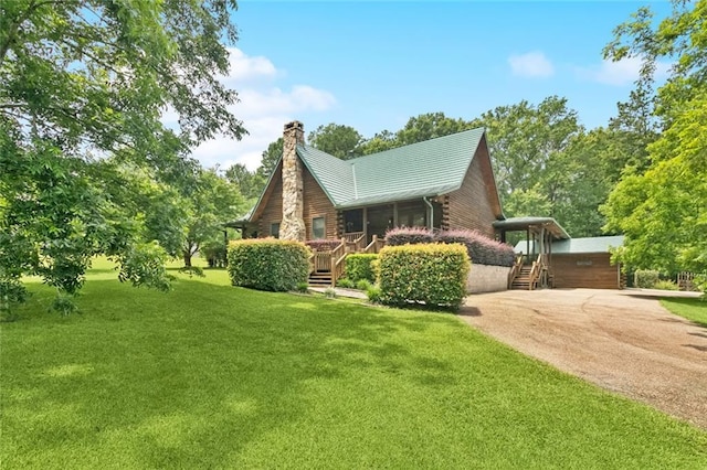 75581 N Hayes Rd, Kentwood, LA 70444 - view of side of home featuring a yard, a chimney, log siding, driveway, and a metal roof