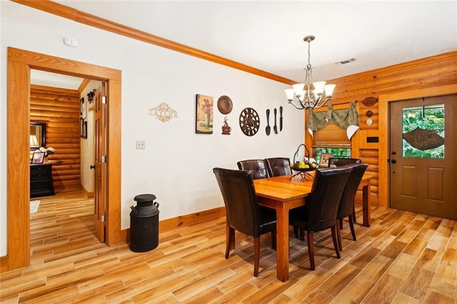 75581 N Hayes Rd, Kentwood, LA 70444 - dining space with log walls, a chandelier, light wood-type flooring, and ornamental molding