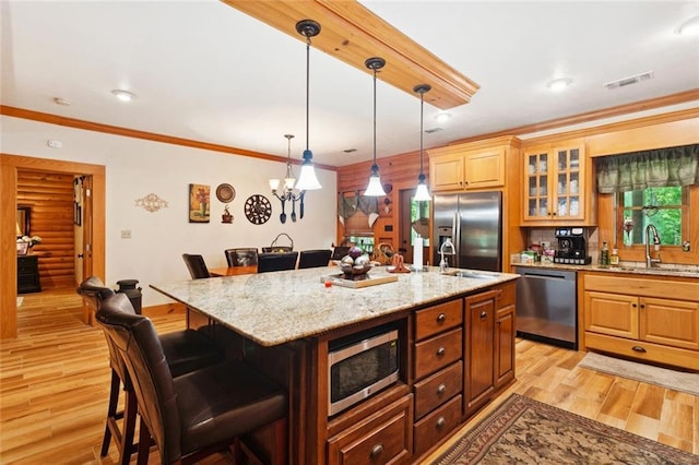75581 N Hayes Rd, Kentwood, LA 70444 - kitchen with stainless steel appliances, a kitchen bar, ornamental molding, light wood-type flooring, and light stone counters