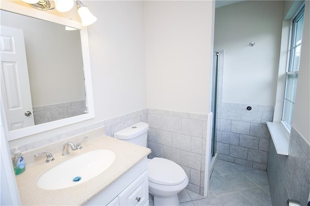 1304 Madewood Rd, La Place, LA 70068 - full bath with tile walls, vanity, an enclosed shower, a wainscoted wall, and tile patterned floors