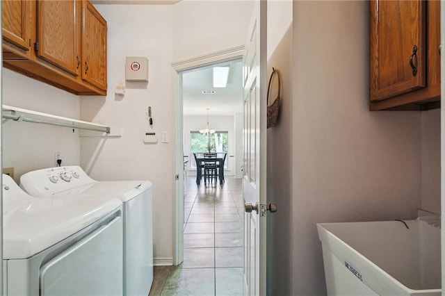 67061 Dolan St, Mandeville, LA 70471 - laundry room with washer and dryer, cabinet space, tile patterned floors, and a chandelier