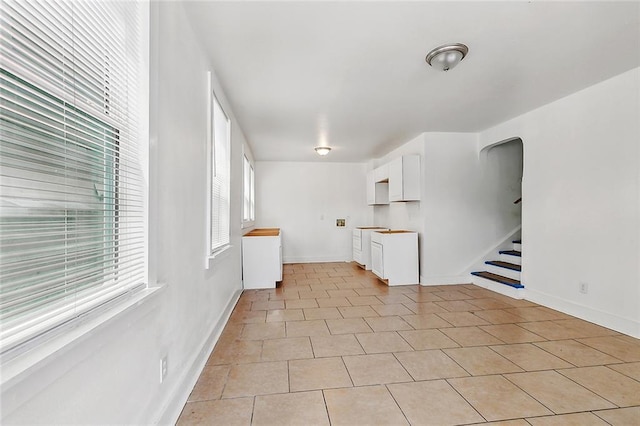 2232 Annette St, New Orleans, LA 70119 - spare room with stairs, light tile patterned floors, and arched walkways
